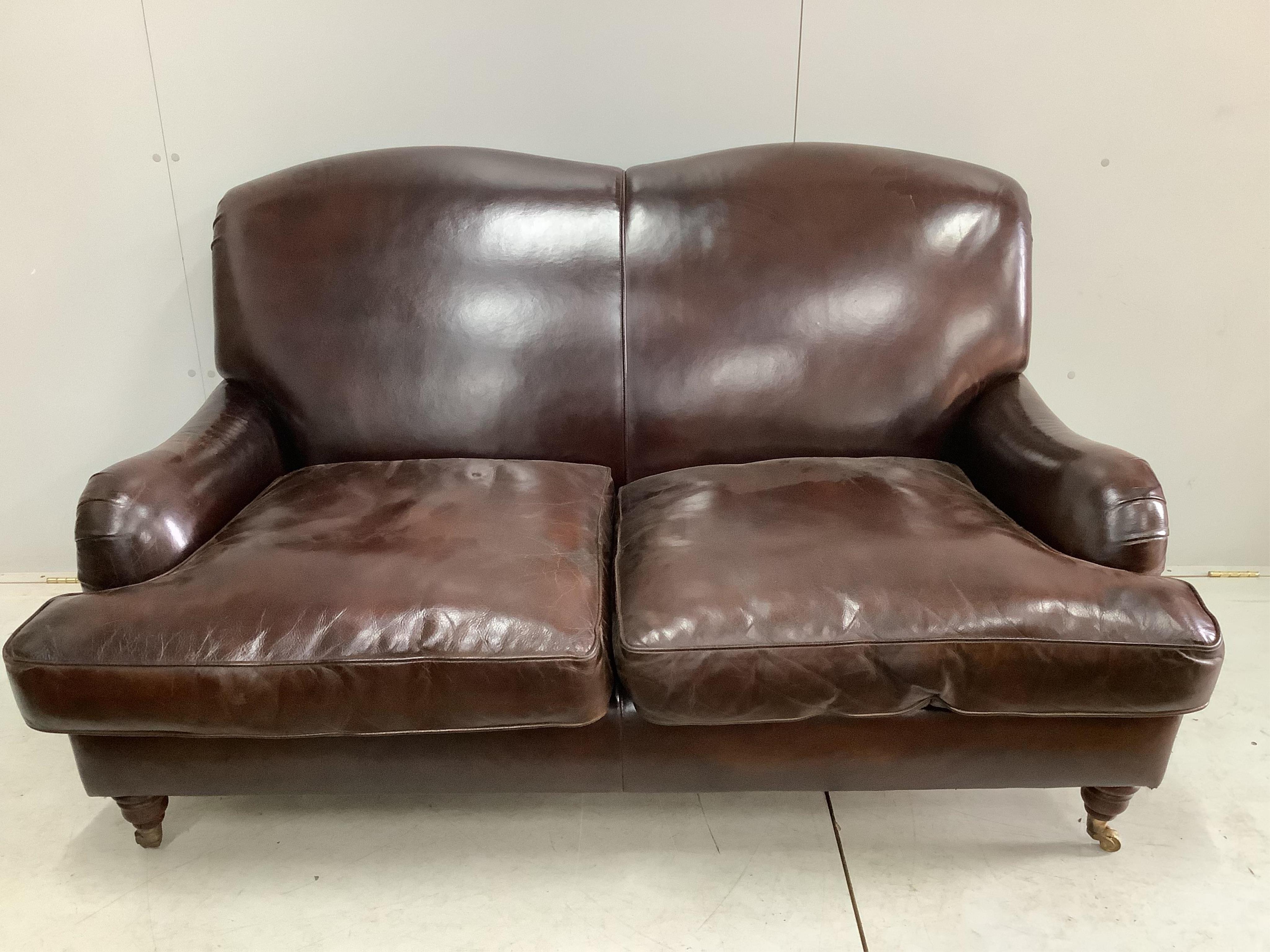 A modern Howard style brown leather two seater settee, width 158cm, depth 88cm, height 88cm. Condition - fair to good